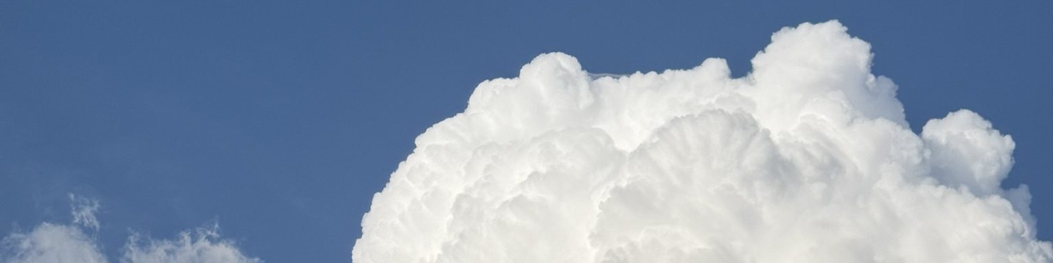 The billowing upper edge of a cumulus cloud against deep blue